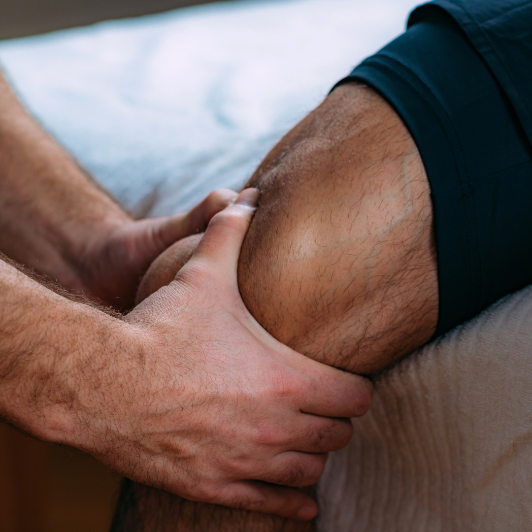 Therapist's hands working around a client's knee