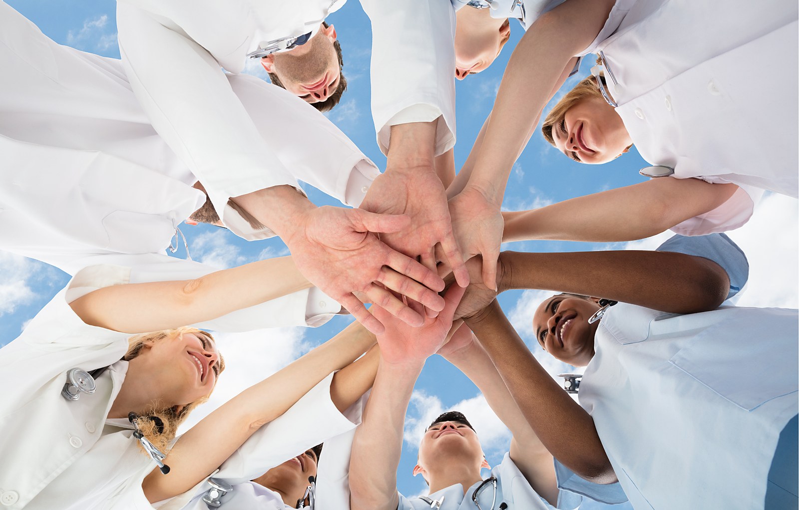 Health care team joining hands in a circle