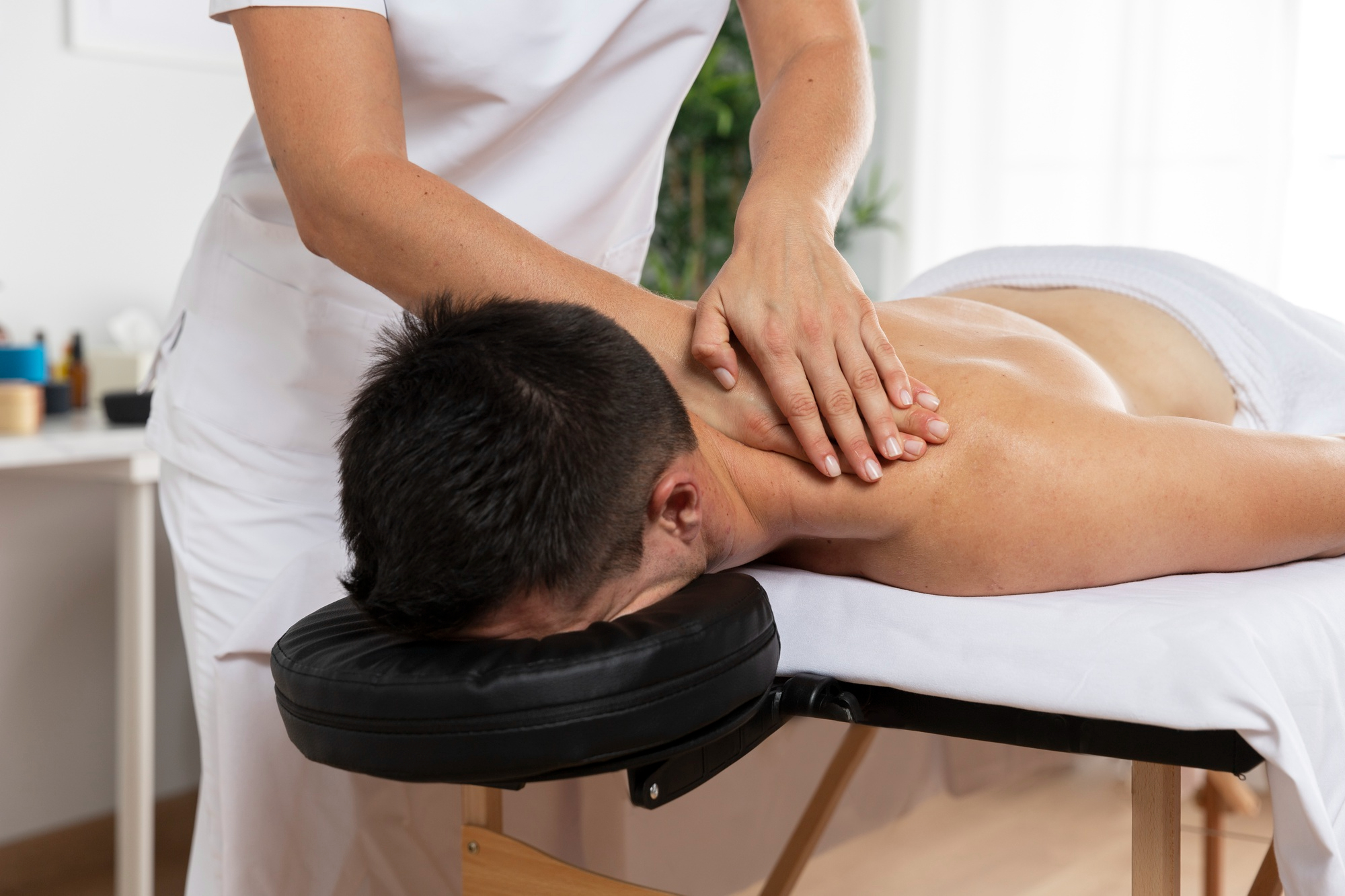 physiotherapist-massaging-patient-office